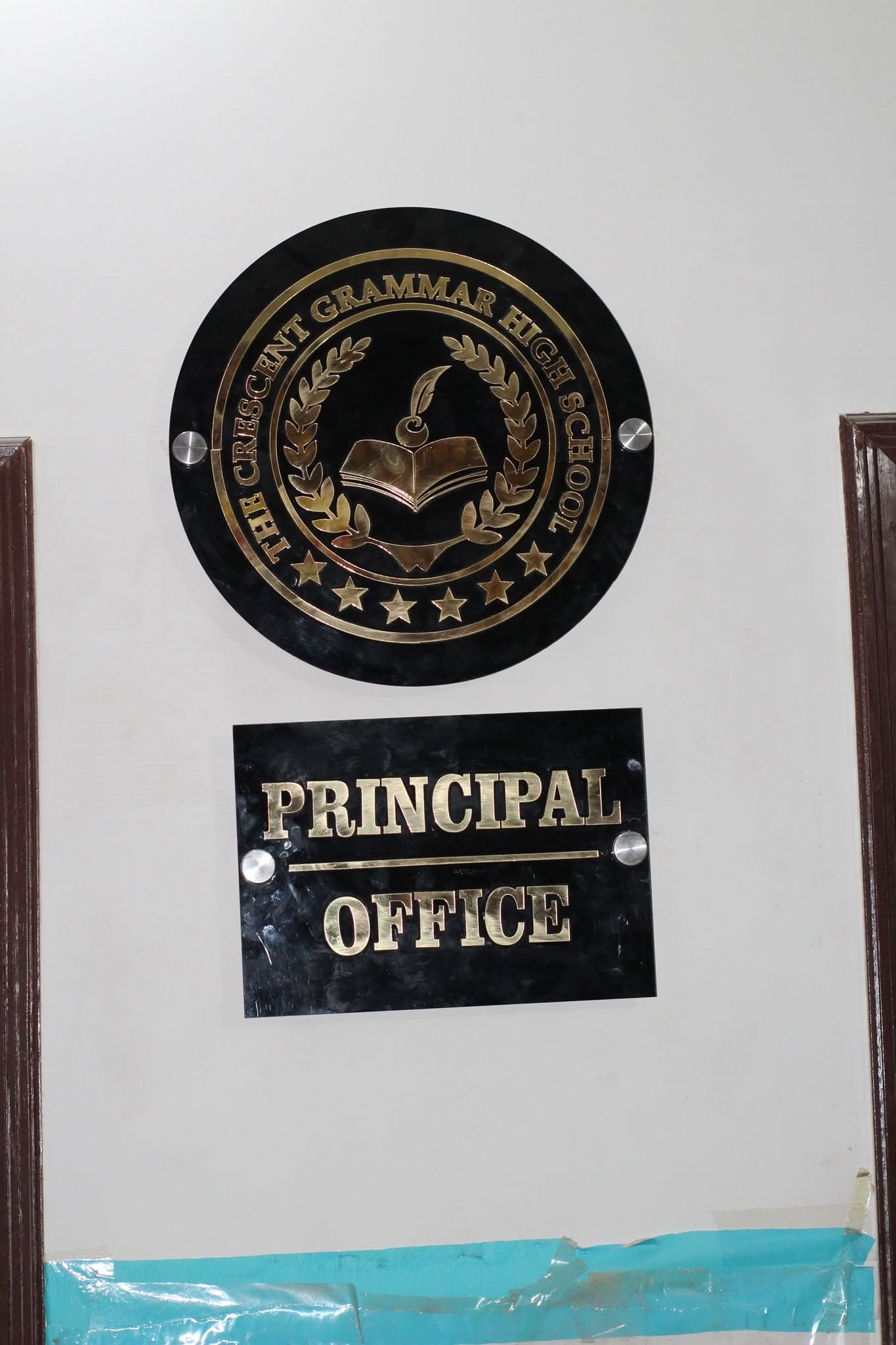 The Crescent Grammar High School's Principal Office signage, bearing the real crest